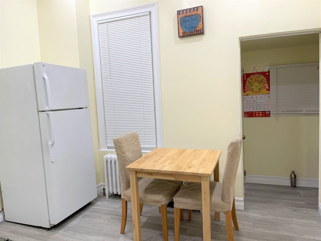 dining area featuring radiator and light hardwood / wood-style flooring