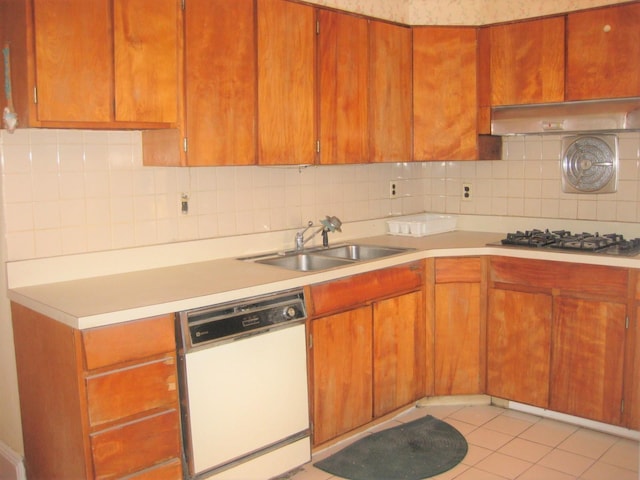 kitchen with gas cooktop, decorative backsplash, white dishwasher, sink, and range hood