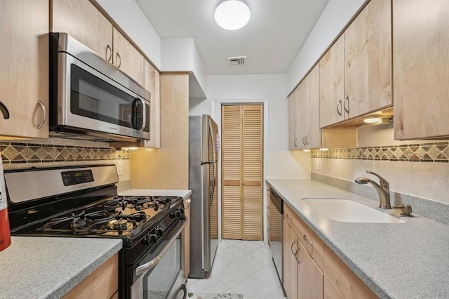 603 55th St Unit 210, West New York, NJ 07093 - kitchen featuring appliances with stainless steel finishes, light brown cabinetry, decorative backsplash, and light countertops