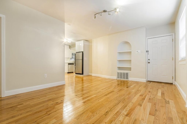330 2nd St, Jersey City, NJ 07302 - unfurnished living room with built in features, light wood-style floors, and baseboards