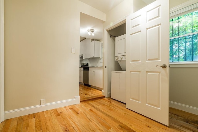 330 2nd St, Jersey City, NJ 07302 - kitchen with stacked washer / dryer, white cabinets, light wood-style flooring, and baseboards