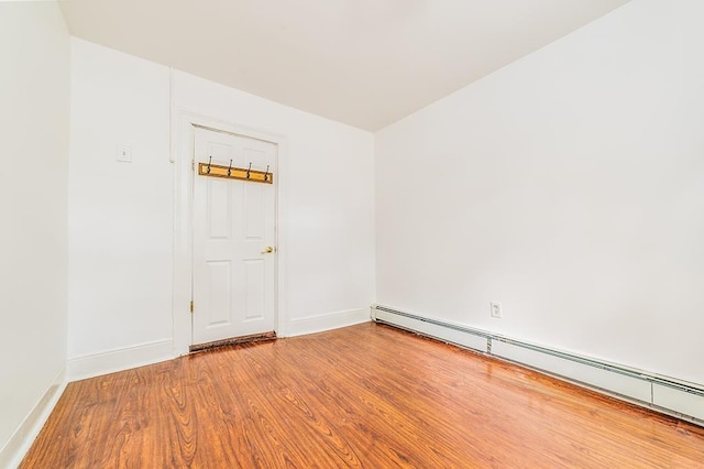 330 2nd St, Jersey City, NJ 07302 - empty room featuring a baseboard heating unit, wood finished floors, and baseboards