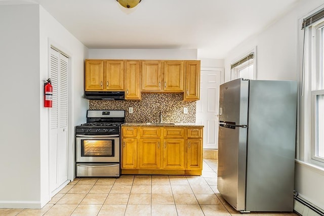330 2nd St, Jersey City, NJ 07302 - kitchen featuring stainless steel appliances, under cabinet range hood, a baseboard heating unit, tasteful backsplash, and light tile patterned floors
