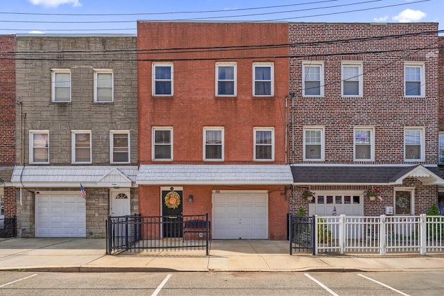 12 Egan Ct, Bayonne, NJ 07002 - view of front facade with an attached garage, brick siding, and driveway