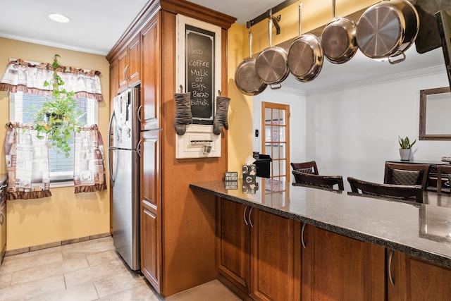 12 Egan Ct, Bayonne, NJ 07002 - kitchen featuring freestanding refrigerator, dark stone counters, brown cabinets, crown molding, and light tile patterned flooring