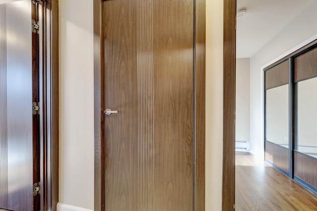 hallway featuring a baseboard radiator and light hardwood / wood-style flooring