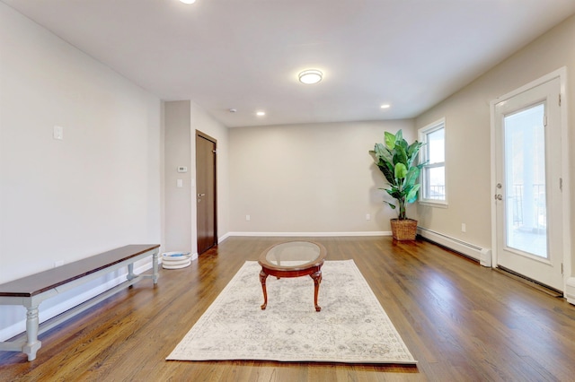 sitting room featuring a baseboard heating unit and dark wood-type flooring