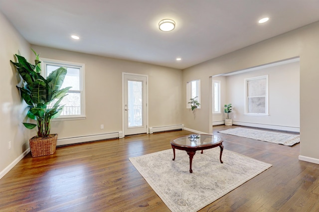 living room with a baseboard heating unit and dark wood-type flooring