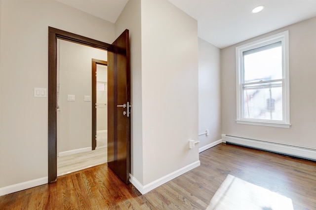 hallway featuring hardwood / wood-style flooring and baseboard heating