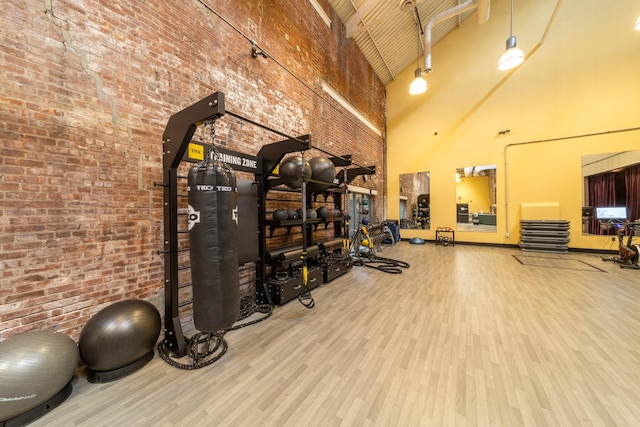 186 Wayne St Unit 423D, Jersey City, NJ 07302 - gym with a high ceiling, wood finished floors, and brick wall