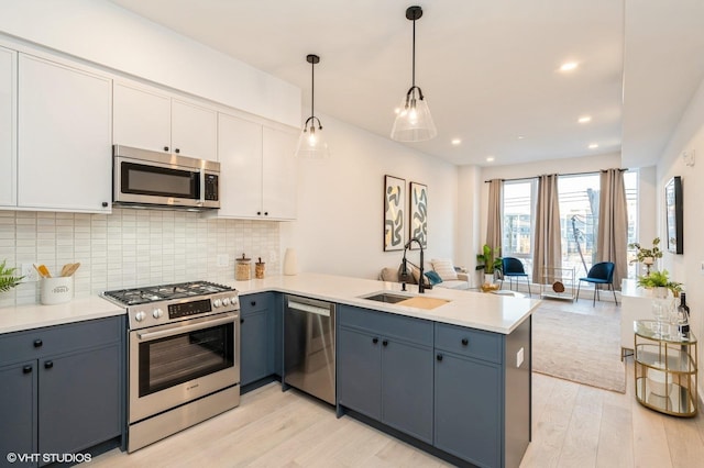 425 3rd St Unit 318, Jersey City, NJ 07302 - kitchen with appliances with stainless steel finishes, light wood-type flooring, a peninsula, a sink, and recessed lighting