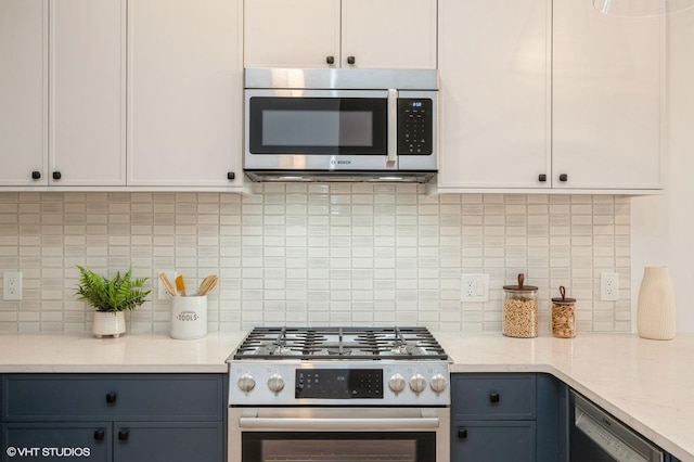425 3rd St Unit 318, Jersey City, NJ 07302 - kitchen featuring stainless steel appliances, decorative backsplash, gray cabinets, light stone countertops, and white cabinetry