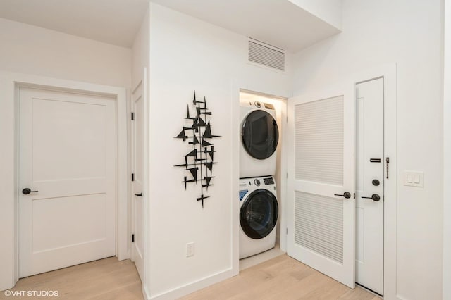 425 3rd St Unit 318, Jersey City, NJ 07302 - laundry area with stacked washing machine and dryer, light wood-style floors, and baseboards