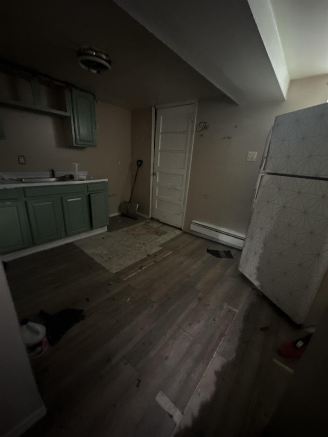 kitchen with baseboard heating, hardwood / wood-style floors, and sink
