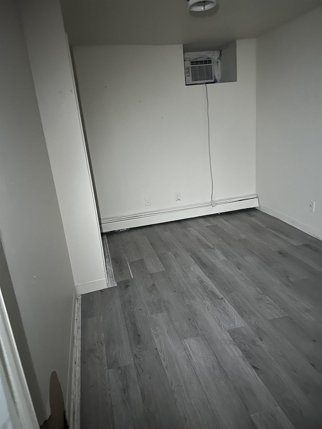 unfurnished room with hardwood / wood-style flooring and baseboard heating