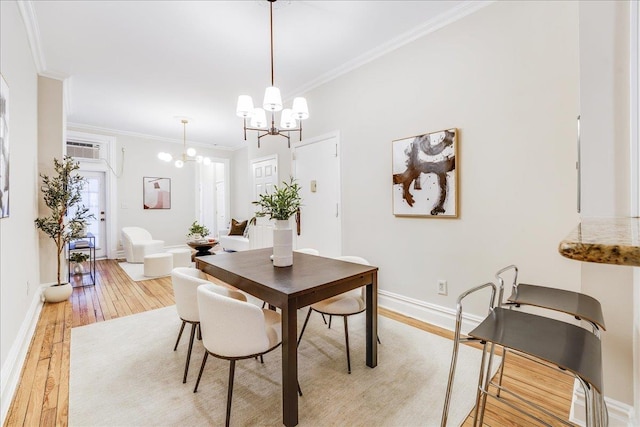 dining room with a wall mounted air conditioner, crown molding, a chandelier, and light wood-type flooring