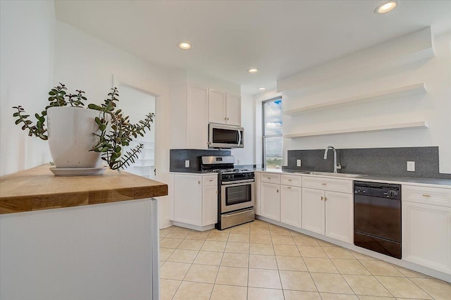 kitchen with white cabinets, stainless steel appliances, tasteful backsplash, and sink