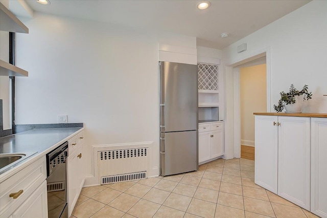 kitchen with white cabinetry, radiator, stainless steel fridge, and dishwasher