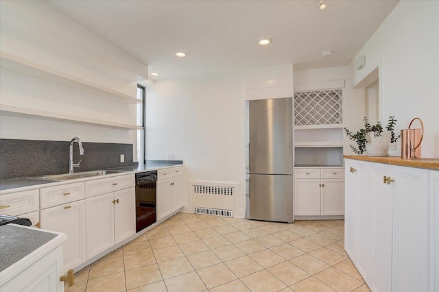 kitchen with stainless steel fridge, sink, white cabinets, radiator heating unit, and black dishwasher