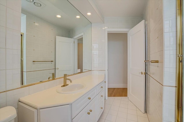 bathroom with tile patterned floors, vanity, and tile walls