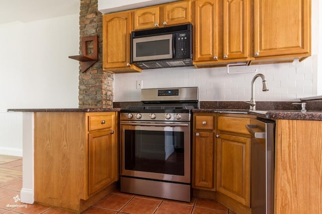 kitchen featuring dark stone counters, tasteful backsplash, light tile patterned floors, and stainless steel appliances