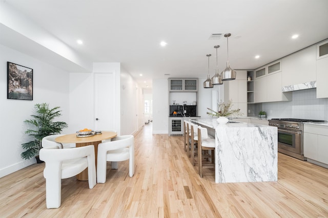 90 Monroe St Unit 2, Hoboken, NJ 07030 - kitchen featuring high end range, a center island, baseboards, light wood-style floors, and recessed lighting