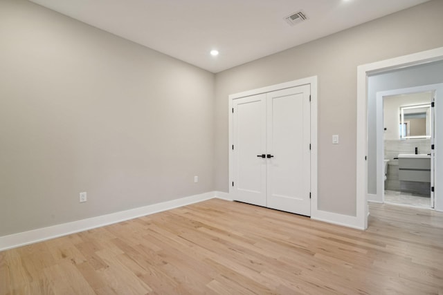 unfurnished bedroom featuring a closet and light wood-type flooring