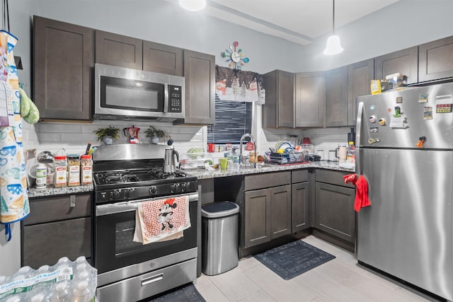 218 68th St, Guttenberg, NJ 07093 - kitchen featuring stainless steel appliances, tasteful backsplash, light stone countertops, decorative light fixtures, and dark brown cabinets