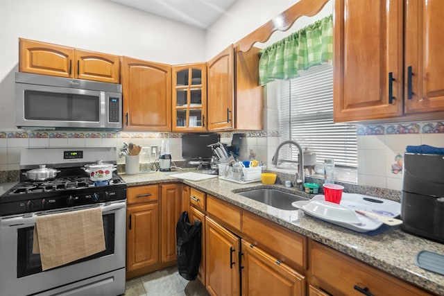 218 68th St, Guttenberg, NJ 07093 - kitchen with stainless steel appliances, light stone countertops, decorative backsplash, and brown cabinets
