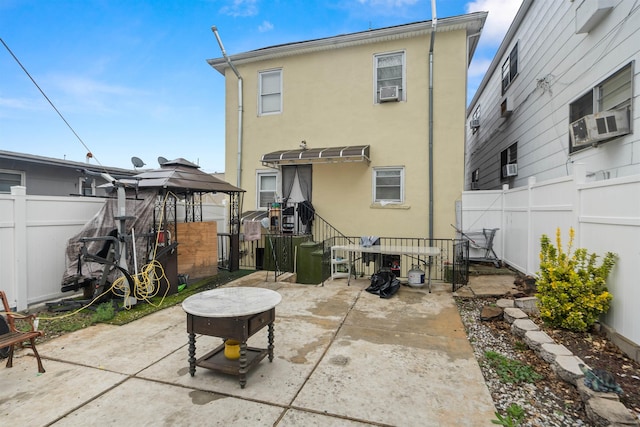 218 68th St, Guttenberg, NJ 07093 - rear view of property with stucco siding, a fenced backyard, a patio area, and a gazebo