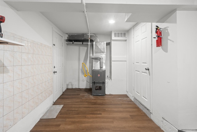 218 68th St, Guttenberg, NJ 07093 - finished basement featuring heating unit, wood finished floors, and tile walls