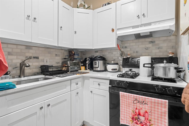 218 68th St, Guttenberg, NJ 07093 - kitchen featuring range with gas stovetop, under cabinet range hood, white cabinetry, decorative backsplash, and light stone counters