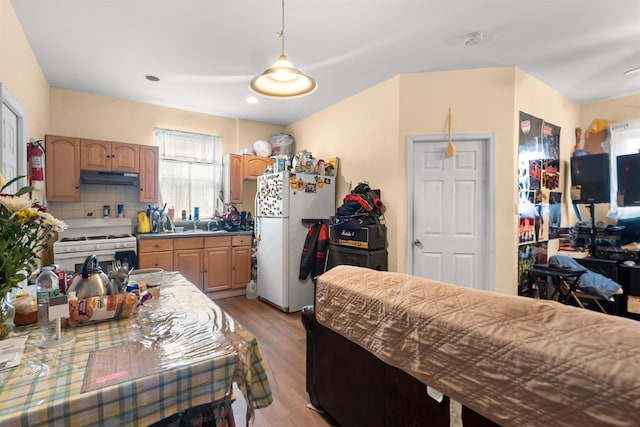 218 68th St, Guttenberg, NJ 07093 - kitchen with white appliances, under cabinet range hood, light wood-style floors, decorative backsplash, and recessed lighting