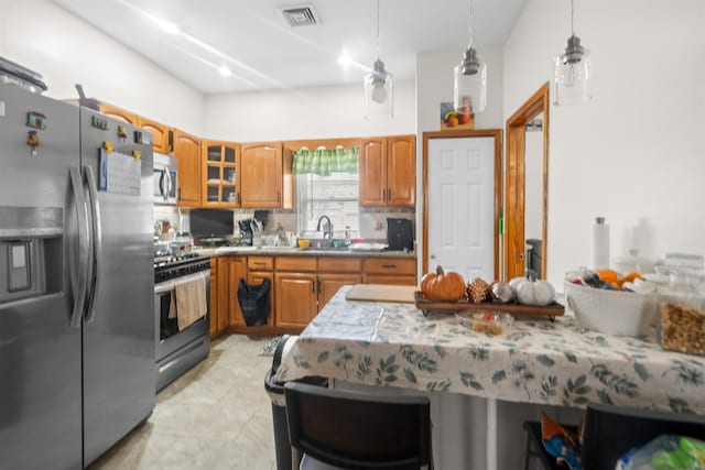 218 68th St, Guttenberg, NJ 07093 - kitchen featuring appliances with stainless steel finishes, brown cabinets, light countertops, and glass insert cabinets