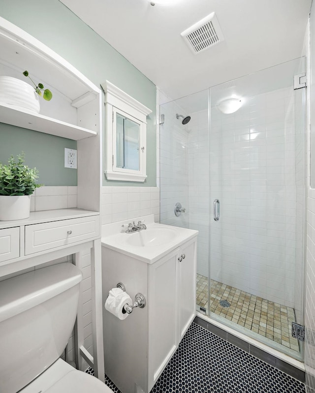 118 Clinton St Unit 7, Hoboken, NJ 07030 - bathroom with tile walls, a shower stall, vanity, toilet, and tile patterned floors