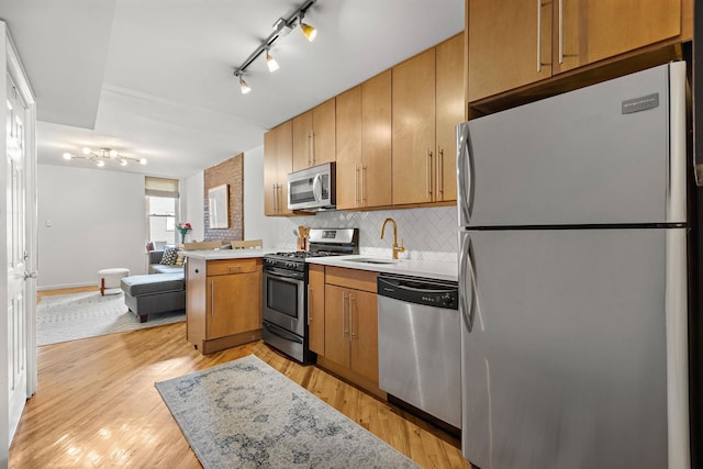 118 Clinton St Unit 7, Hoboken, NJ 07030 - kitchen featuring appliances with stainless steel finishes, a sink, track lighting, backsplash, and light countertops