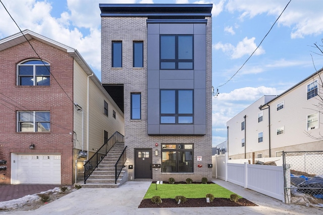 13 Manhattan Ave Unit 1, Jersey City, NJ 07307 - view of front of home with brick siding, stairway, and a garage