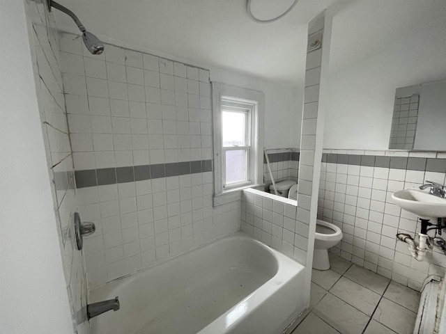 full bathroom featuring tile patterned floors, toilet, sink, tile walls, and tiled shower / bath combo