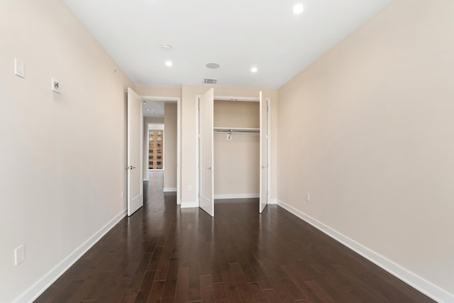 unfurnished bedroom featuring visible vents, a closet, baseboards, recessed lighting, and dark wood finished floors