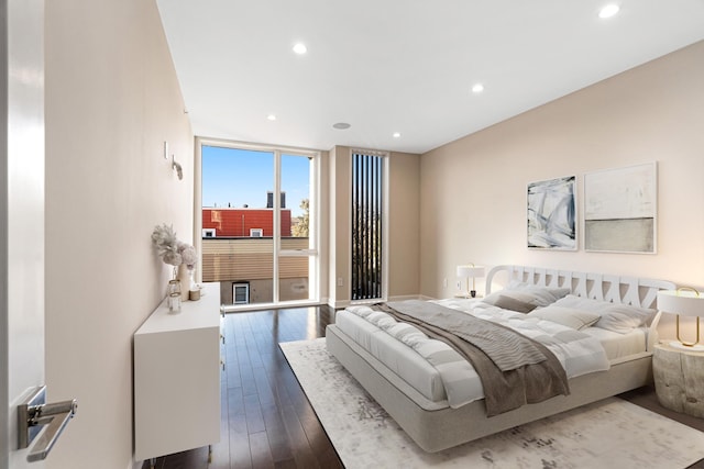 bedroom with recessed lighting, dark wood-style floors, and expansive windows