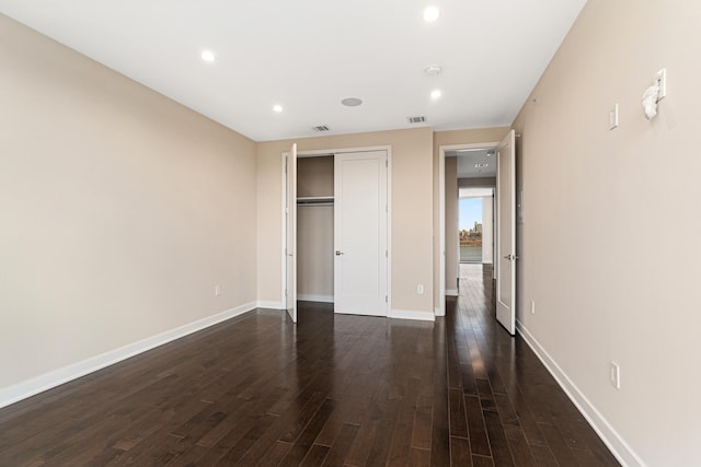 unfurnished bedroom featuring visible vents, a closet, recessed lighting, and dark wood-type flooring