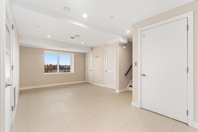 empty room featuring recessed lighting, baseboards, and light tile patterned flooring