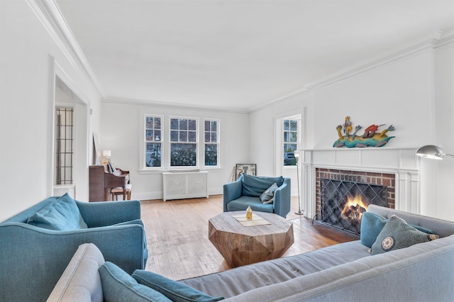 living area with crown molding, baseboards, a brick fireplace, and wood finished floors