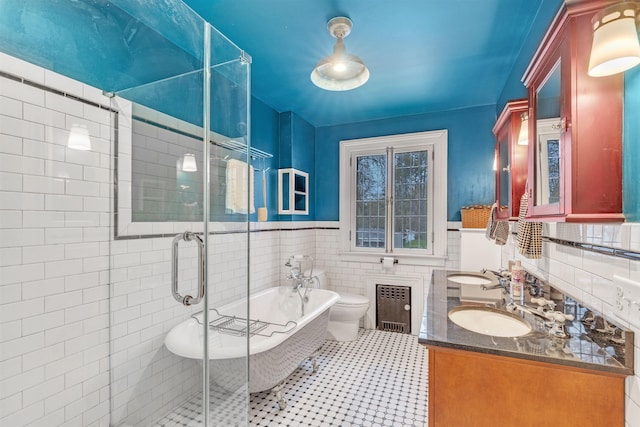bathroom with radiator, tile patterned floors, a soaking tub, a sink, and a stall shower