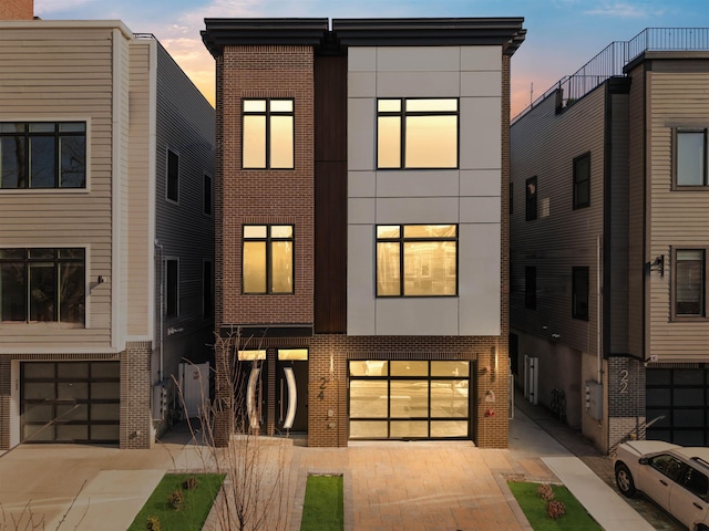 contemporary home featuring driveway, stucco siding, and brick siding