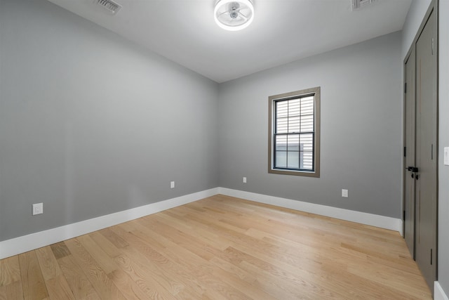 unfurnished room featuring light wood finished floors, baseboards, and visible vents