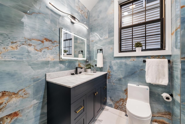 bathroom with toilet, tile walls, and vanity