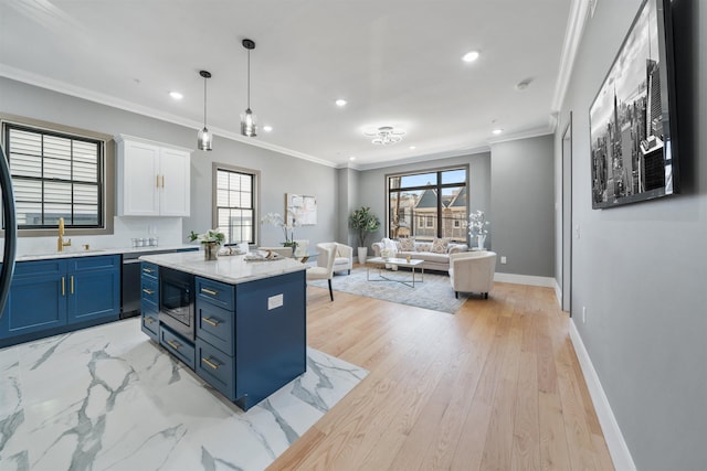 kitchen with blue cabinetry, open floor plan, white cabinetry, a kitchen island, and built in microwave