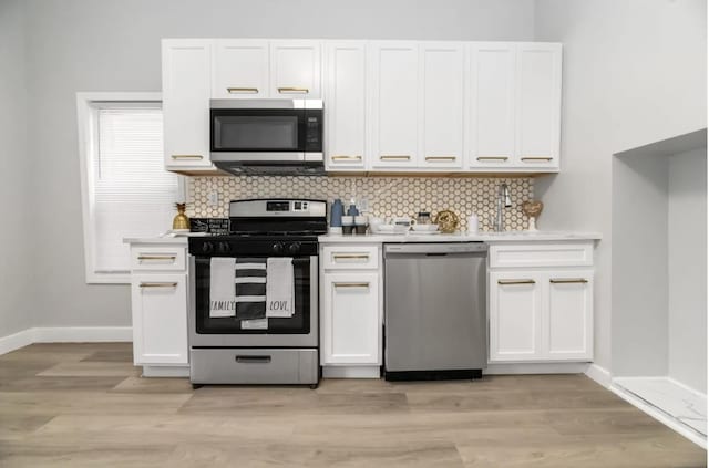 330 Forrest St, Jersey City, NJ 07304 - kitchen featuring appliances with stainless steel finishes, white cabinets, light countertops, decorative backsplash, and light wood finished floors