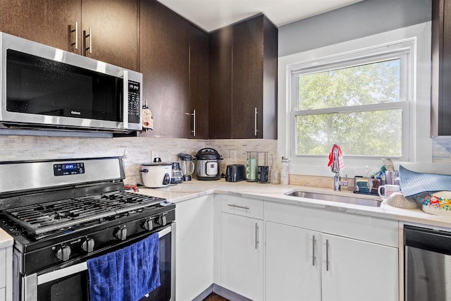 70 County Ave, Secaucus, NJ 07094 - kitchen with stainless steel appliances, a sink, dark brown cabinetry, backsplash, and white cabinetry